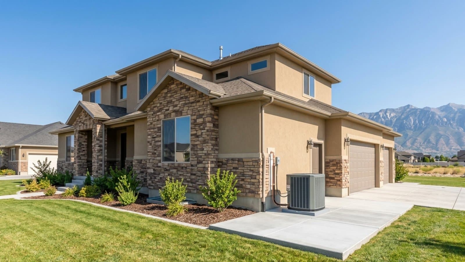 Newly installed AC condenser beside a two-story stucco-and-stone home with Wasatch Mountain views in Riverton, Utah